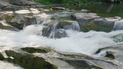 一条清澈的山河的小溪，水流过巨大的岩石