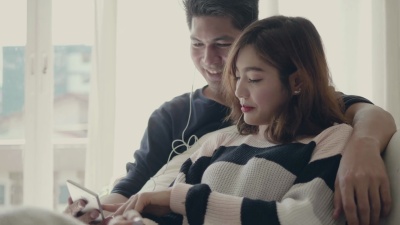 亚洲夫妇在家用智能手机听音乐