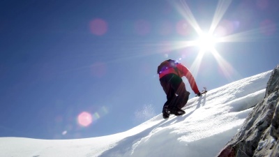登山者到达白雪覆盖的山峰