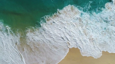空中无人驾驶飞机拍摄的海浪到达岸边的镜头。