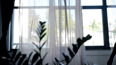 可爱的女人早上伸展在窗边