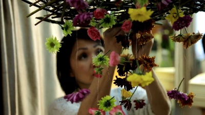 中国女人用花环装饰房间的内部