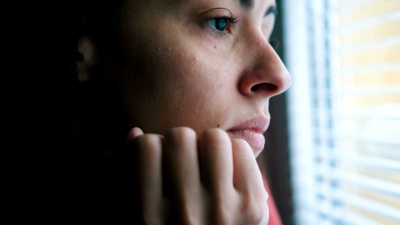 悲伤的女人透过窗户看