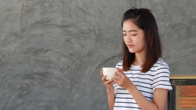 美丽的女孩喝着热咖啡