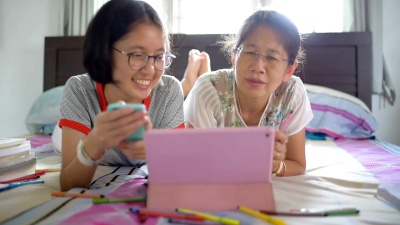 亚洲家庭使用数字平板电脑和智能手机在家工作，并通过网上购物放松