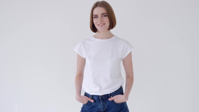 穿着牛仔裤短裤和白色T恤的美女交叉双臂摆姿势