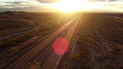 空中 夏季日落时分在繁忙的高速公路上行驶的汽车和半卡车