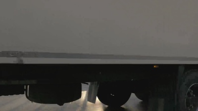 沥青路面上行驶的集装箱轮式卡车