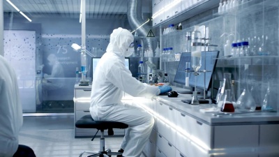 在一个安全的高级实验室里，科学家们在一个整体上进行研究。生物学家用钳子调整培养皿中的样本，然后在显微镜下检查，他的同事在计算机上分析结果。
