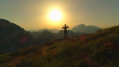 空中 女孩徒步登山和庆祝成功攀登的剪影。