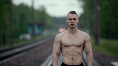 肌肉强壮的男人站在铁轨上