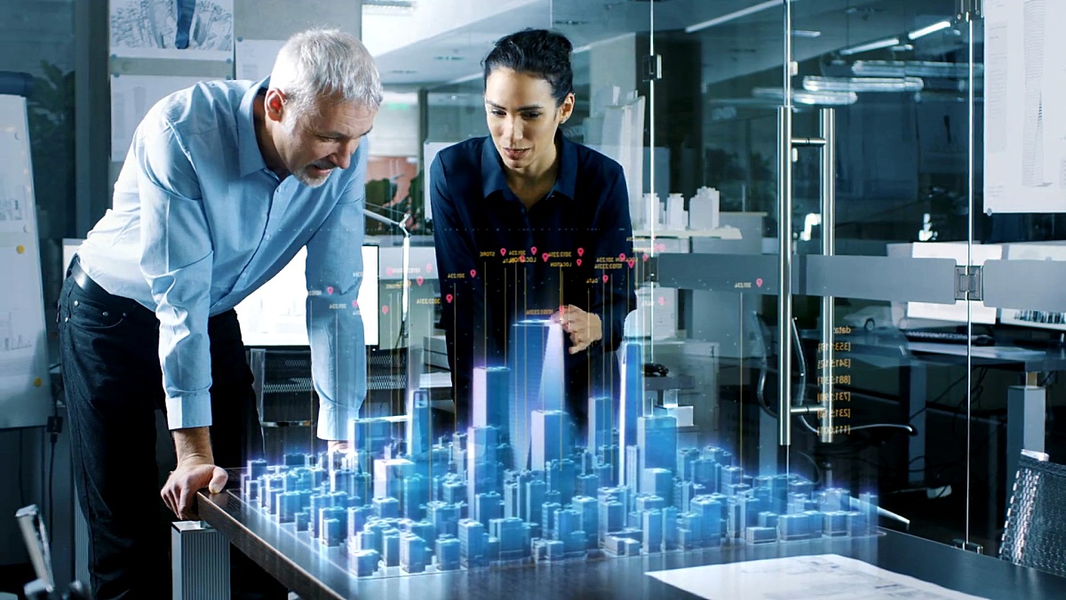 男性和女性建筑师使用全息增强现实3D城市模型。技术先进的Office专业人员使用虚拟现实建模软件应用程序。