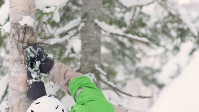 滑雪者或滑雪者戴着头盔护目镜绿色夹克吃雪冰冻的雪胡子快乐的生活方式山森林