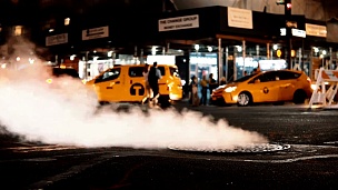 美国纽约市中心交通道路上带有飞烟、烟雾的检修井盖的特写视图