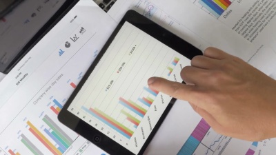 财务分析师在数字平板电脑上看到图表和图形