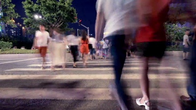 行人在城市街道的斑马线上行走，延时摄影。