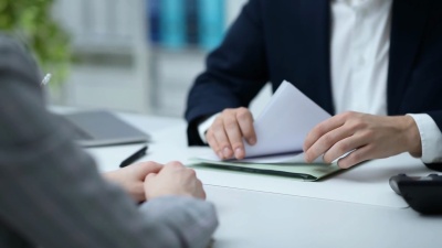 商务人员在办公室开会并签订合同，该男子指着并给出解释，协议和伙伴关系的概念