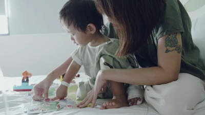 年轻的母亲在医院和小男婴一起玩耍