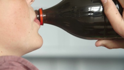 男孩用瓶子喝苏打水的特写镜头