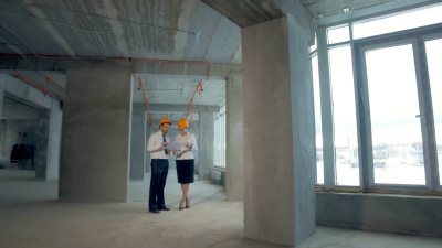 建筑师和投资人，商人检查新建筑内部施工。平滑的相机移动，稳定的摄像头拍摄