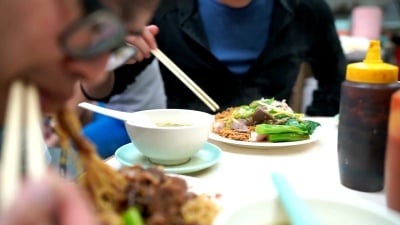 男人吃猪肉炒面和煮猪肝，香港，中国菜。