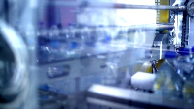 塑料瓶中的清洁水通过传送带工厂流动。