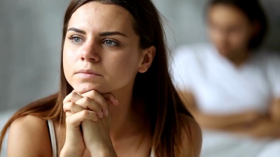 忧心忡忡的女人在吵架后感到被冒犯心烦意乱，男人在背后