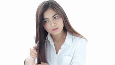 年轻快乐的女人在浴室的镜子前梳头