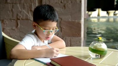 男孩在桌子上做作业