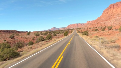 FPV驾驶着穿过红色岩石沙漠中的台地山脉的国会珊瑚礁公园(Capitol Reef Park)