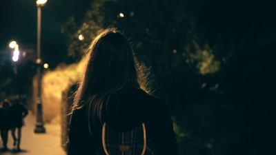 年轻的深色头发的女人在深夜独自行走。女孩穿过罗马市中心，意大利竞技场附近