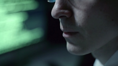 戴眼镜的程序员夜间在电脑上工作