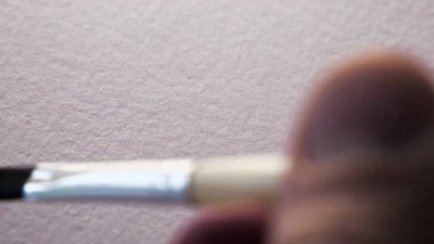 毛笔在白纸上画黑墨。微距拍摄与惊人的墨水流血
