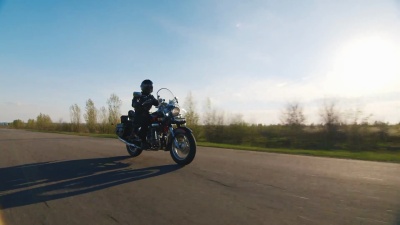 骑摩托车在乡村公路上，阳光照耀着它