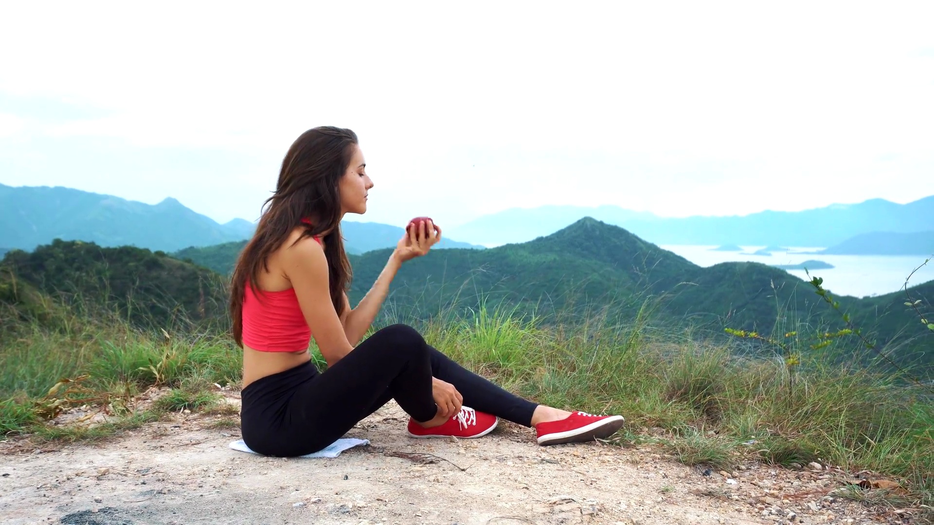 赛跑女子在山顶吃苹果