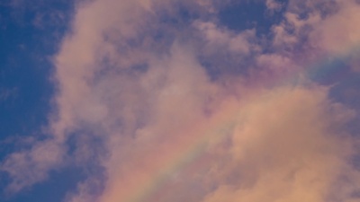 彩虹在天空中的延时摄影和日落的多云