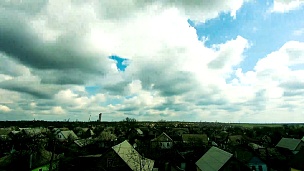 天空中的云在城市的房屋上移动。时间间隔