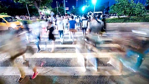 行人在城市广州街道的斑马线上行走，延时摄影。