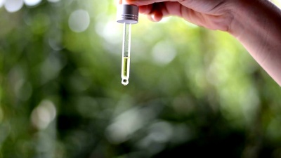 女性手持吸管，精华液落入玻璃瓶