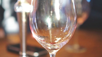 将红葡萄酒从瓶子倒进玻璃杯。酒渣。