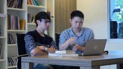 两个学生坐在笔记本电脑上工作