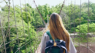 亚洲女人在木吊桥上行走