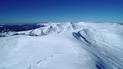 飞越白日阳光照耀下的青松石色雪山