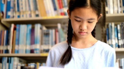 4K亚洲青少年学生在学校图书馆看书的灵感，用自然光拍摄，慢动作拍摄