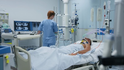 ICU护士检查一名年轻男性患者的机械通气