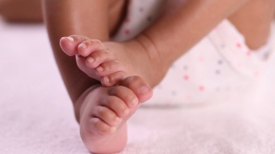 新生儿的脚妈妈抱着新生婴儿的腿