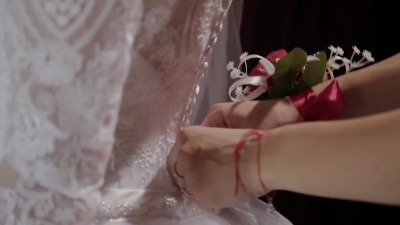 男人在新娘的婚纱上系上胸衣