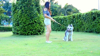 快乐的亚洲女人牵着她的狗