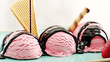 将巧克力酱倒在草莓冰淇淋上