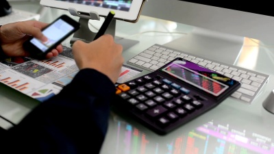 商人在办公室使用数字平板电脑和笔记本电脑分析股票市场